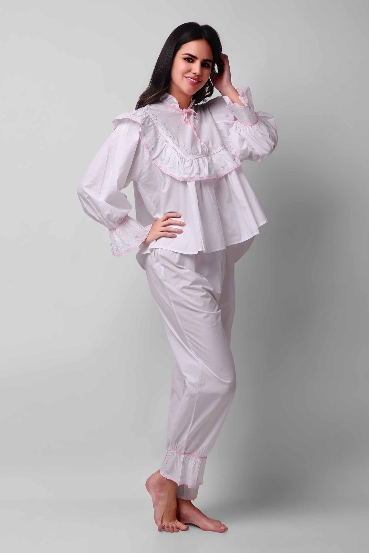 Elegant woman modeling Mary Pyjama Suit in white with pink accents.