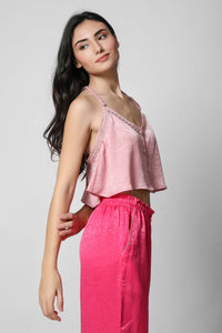 Model in pink crop top and matching pants, showcasing stylish comfort.