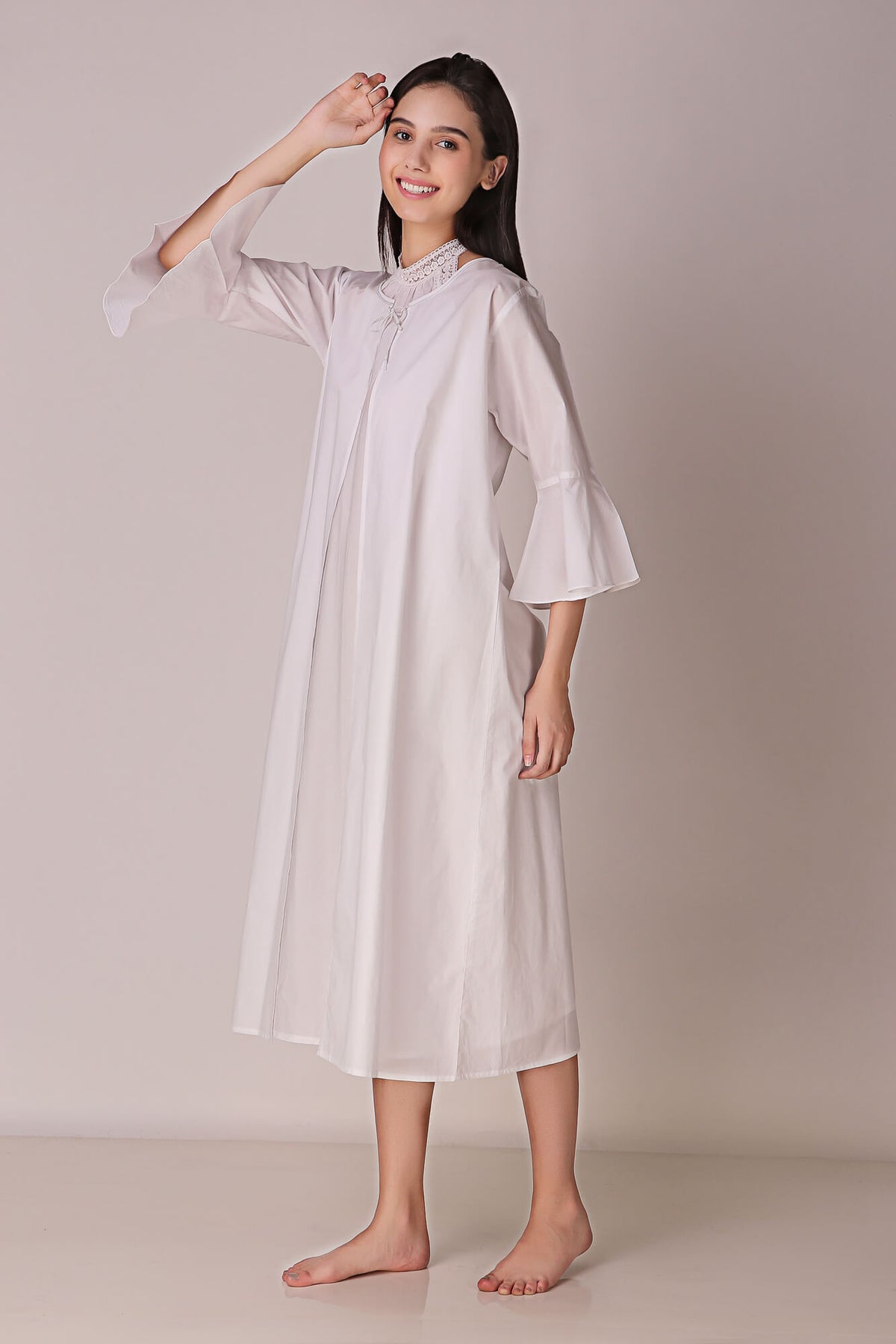 Model wearing Talisa backless dress in soft white fabric.