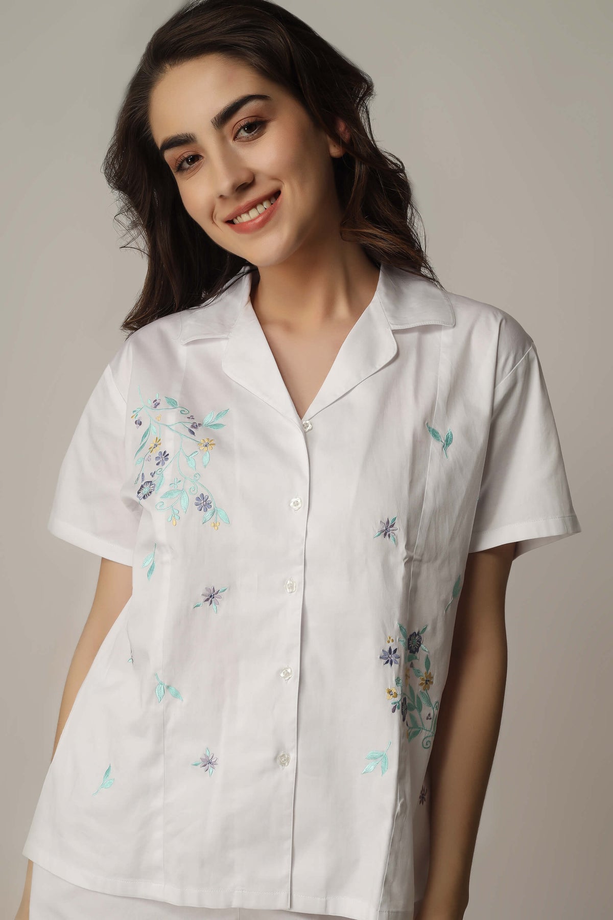 Model wearing embroidered white top from Aviv, stylish and elegant design.