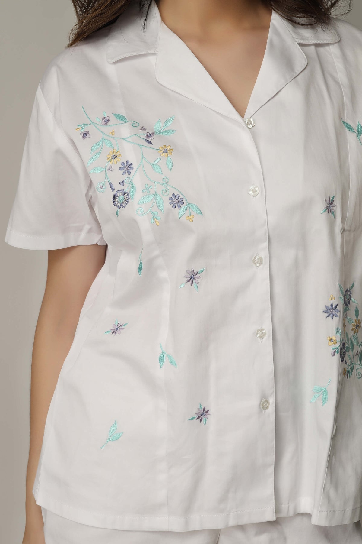 Women's white top with floral embroidery, part of the Aviv set.