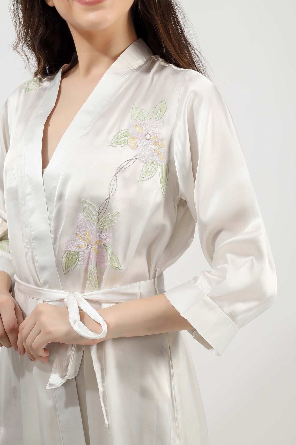 Elegant embroidered gown featuring floral designs on soft fabric.