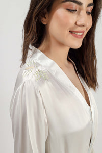 Elegant embroidered gown featuring delicate floral designs and soft fabric.