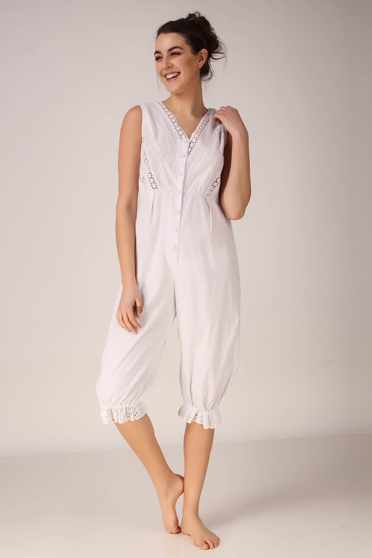 Elegant white Enola romper with lace details and buttons.