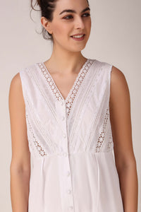 Elegant white Enola romper with detailed lace design and button-up front.