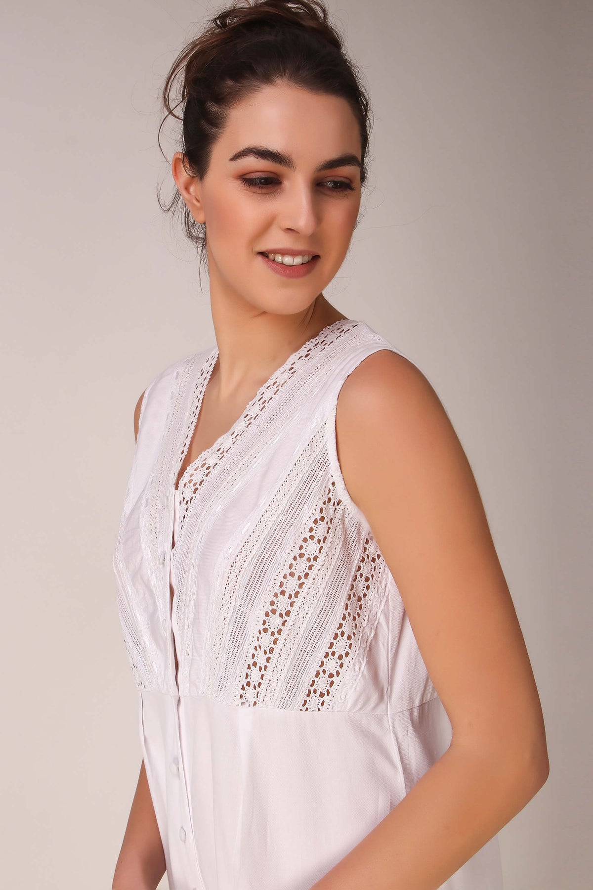 Stylish white Enola romper with lace detailing and button closure.