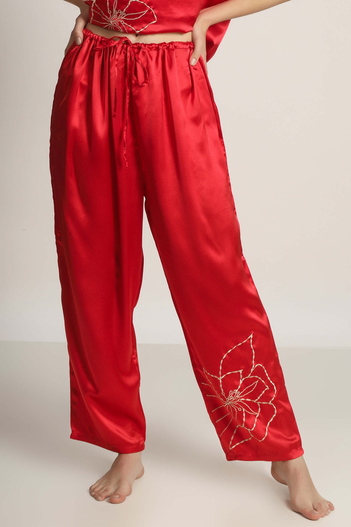 Red satin pyjama suit with floral embroidery detail for women.