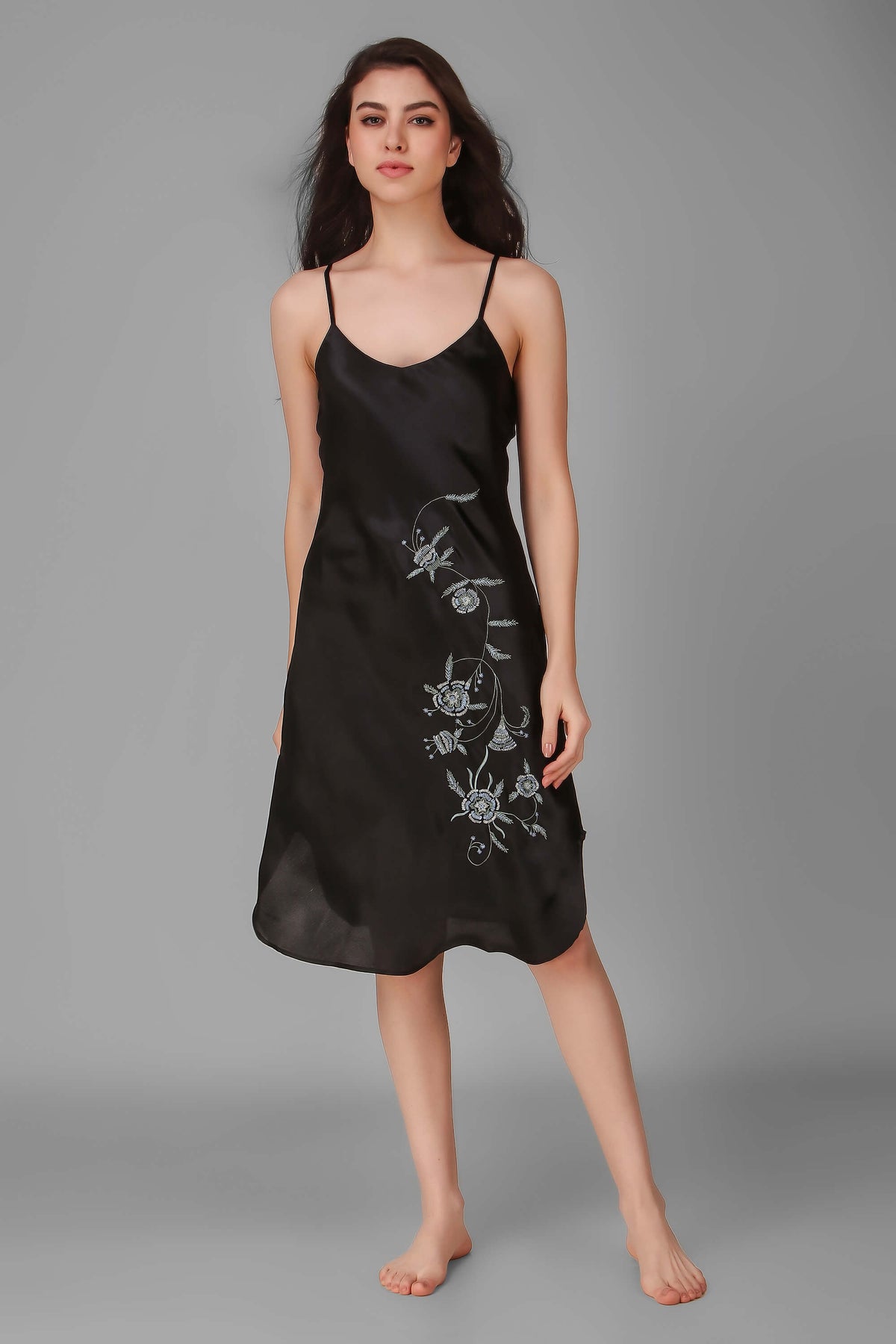 Elegant black Andromeda dress with floral embroidery on the side.
