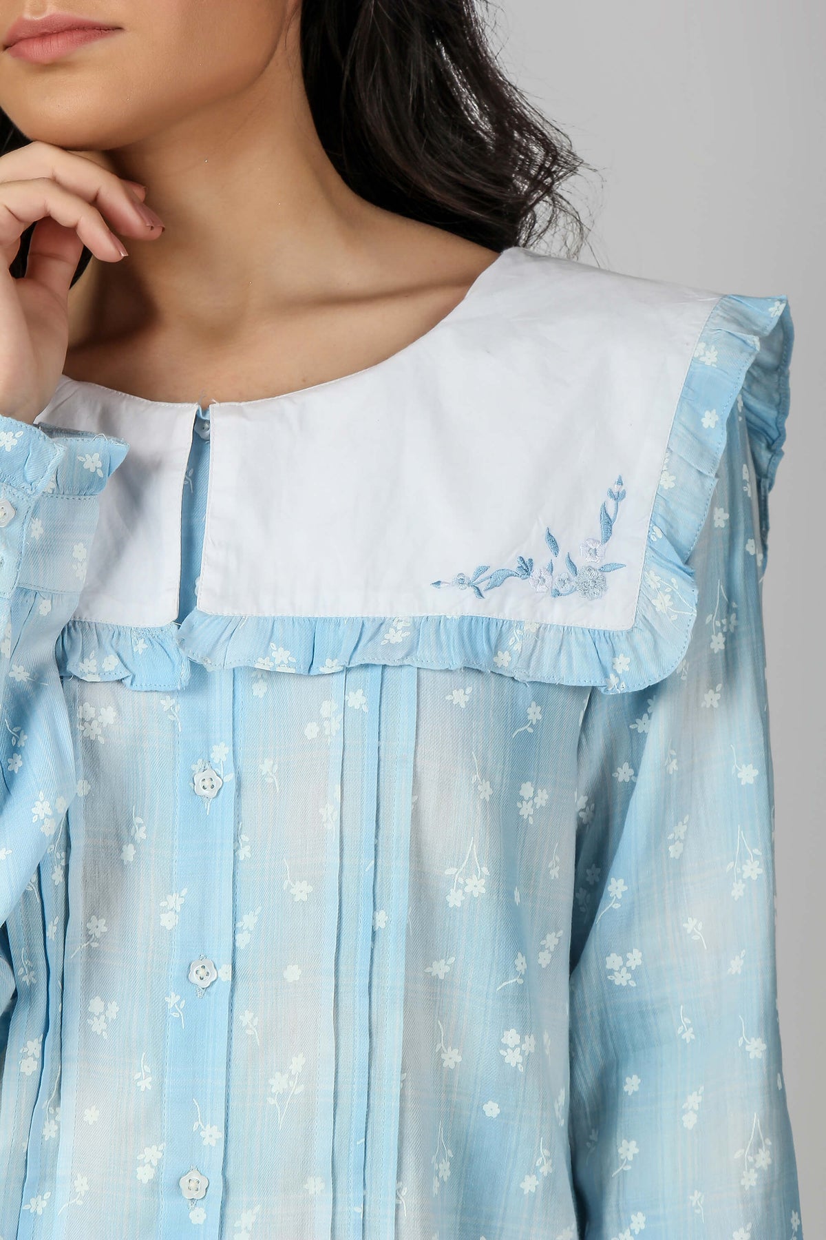 Light blue sailor pyjama suit with floral pattern and ruffled collar.