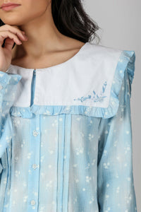 Light blue sailor pyjama suit with floral pattern and ruffled collar.