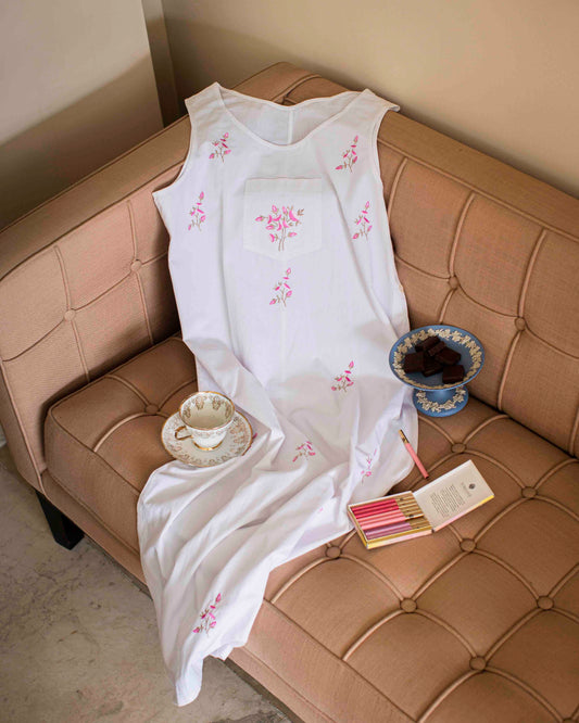 White embroidered dress with floral design on a couch.