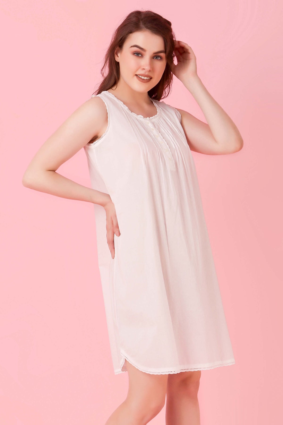 Elegant woman modeling Jia nightdress against a soft pink background.