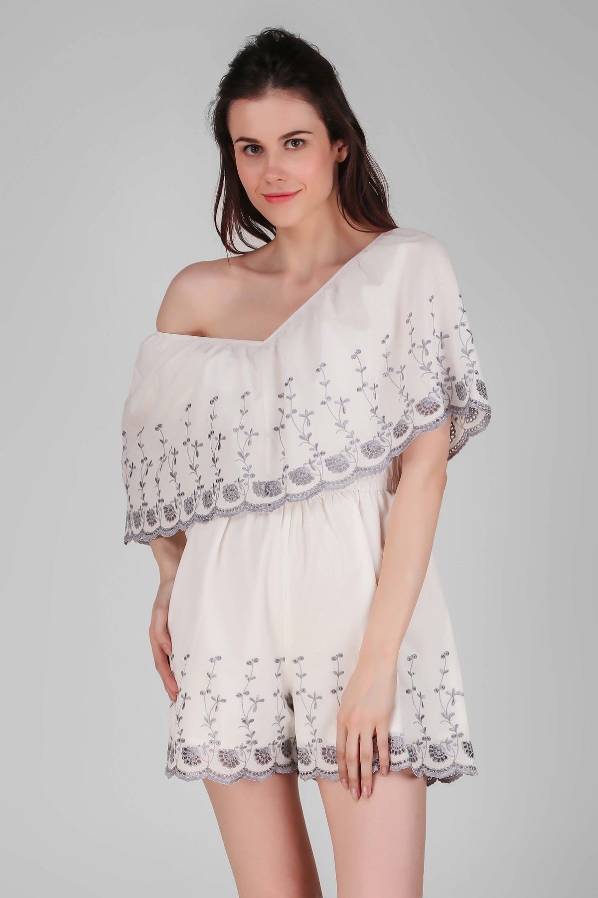 Stylish white Joyce romper with floral embroidery and off-shoulder design.