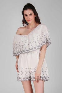 Stylish white Joyce romper with floral embroidery and off-shoulder design.